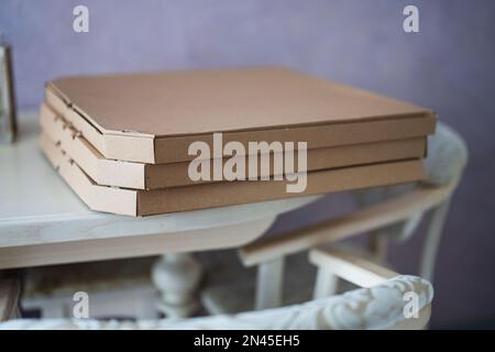 Pizzaschachteln aus Pappe auf der Küche auf dem Tisch. Stockfoto