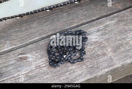 Neue Kette für Motorsäge. Aufbau und Austausch der Kette an der Motorsäge von der alten zur neuen. Schärfen der Kette. Stockfoto