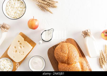 Festlicher Hintergrund zur Feier des jüdischen Frühlings shavuot. Traditionelle Leckereien und Symbole des Urlaubs. Draufsicht. Flaches Design Stockfoto