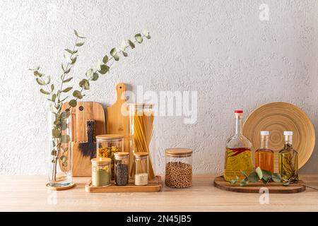 Ein Set mit verschiedenen gefüllten Dosen und Flaschen auf der Küchenarbeitsfläche. Dekorativer Lagerbereich. Schneidebretter. Umweltfreundliche Lagerung Stockfoto