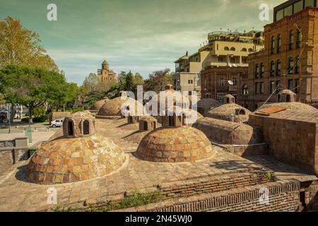 Schwefelbäder in Tiflis in der Innenstadt. Neben dem Geidar Aliev Park und dem Fluss Kura. In der Ferne - Metekhi Kirche der Geburt der Heiligen Jungfrau Maria Stockfoto