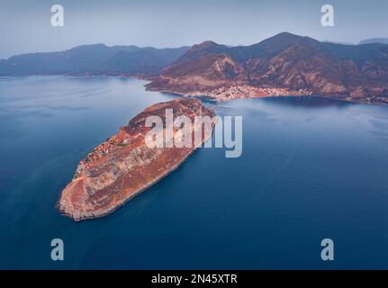 Nebeliger Sommerblick auf die Insel Monemvasia mit der Stadt Gefira im Hintergrund. Malerische Außenlandschaft der Halbinsel Peloponnes, Griechenland, Europa. Luftmeere Stockfoto