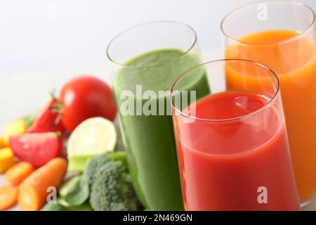 Verschiedene leckere Säfte in Gläsern auf weißem Hintergrund, Nahaufnahme. Platz für Text Stockfoto