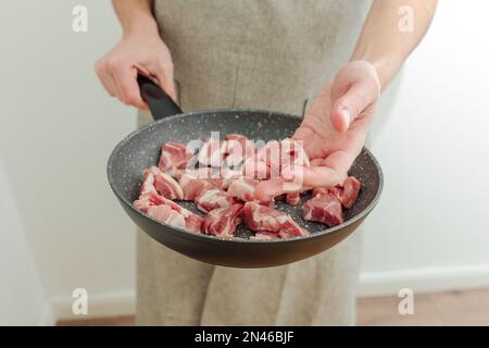 Frisch gehacktes Fleisch in einer Bratpfanne in den Händen. Stockfoto