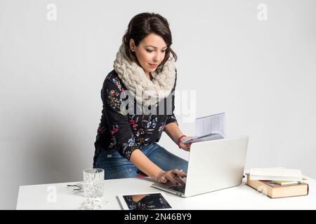 Lächelnde Modedesignerin, die an einem Laptop in einem Kreativbüro arbeitet Stockfoto