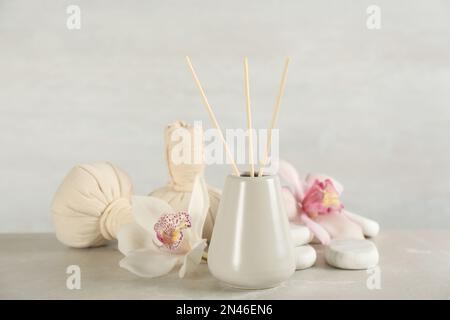 Wunderschöne Komposition mit Schilf-Lufterfrischer und Spa-Steinen auf Marmortisch Stockfoto