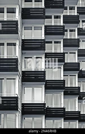 Abstraktes Schwarz-Weiß-Foto von der Fassade des einheitlich gestalteten Apartmentblocks mit Balkonen Stockfoto