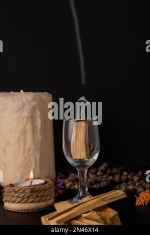 palo santo rauchen, heiliger Stock mit Kerzen und japa-mala auf schwarzem Hintergrund Stockfoto