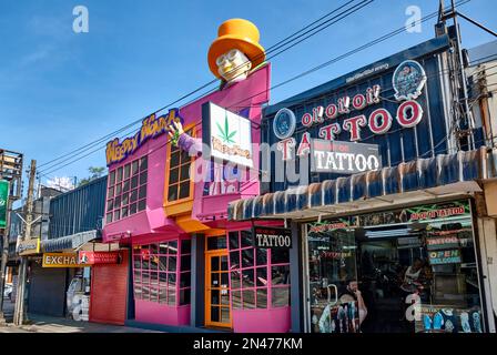 Ein exzentrisches, asymmetrisches rosa Gebäude in Bangla Rd., Patong, Phuket, Thailand, mit Cannabisladen Weedly Wonka, mit einem Tattoo-Salon nebenan Stockfoto