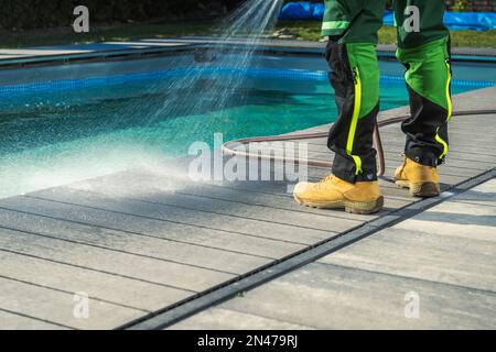 Außenreinigung Am Pool Mit Gartenschlauch. Swimmingpool, Terrassenpflege Aus Verbundwerkstoff Stockfoto