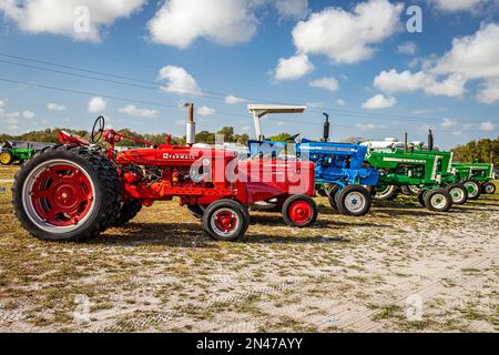 Fort Meade, Florida - 22. Februar 2022: Weitwinkel-Seitenansicht von Gruppentraktoren auf einer lokalen Traktormesse. Stockfoto