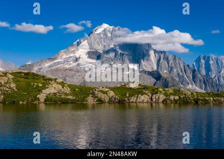 Der Gipfel von Aiguille Verte, Grand Dru bedeckt mit Wolken, über der Oberfläche von Lacs des Chéserys zu sehen. Stockfoto