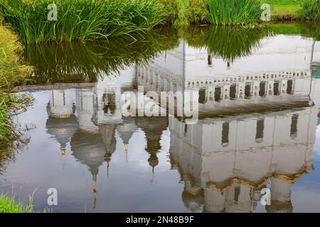 Reflexion im Wasser einer orthodoxen Weisssteinkirche. Stockfoto