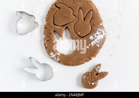 Roher osterkuchen-Teig mit Schneidemehl und Mehl. Zubereitung von Osterkeksen. Weißer Hintergrund Stockfoto