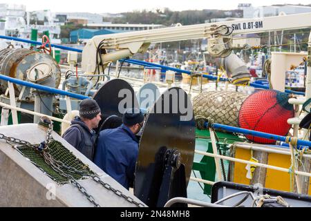 Killybegs Fischereihafen, Männer arbeiten an Winden auf einem Trawler, der in der Grafschaft Donegal, Irland, festgemacht ist Stockfoto