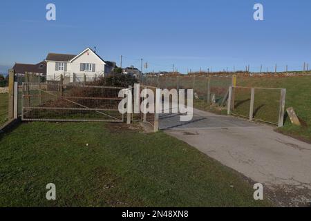 Das Rindergitter an einem Ende des Dorfes zeigt das geschlossene Tor für die sichere Bewegung von Tieren um das Gitter. Stockfoto