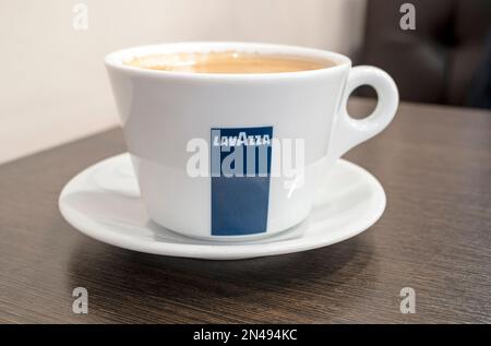 BERLIN - FEBRUAR 23: Nahaufnahme einer Kaffeetasse mit Lavazza-Logo auf einem Holztisch in Berlin am 23. Februar. 2022 in Deutschland Stockfoto