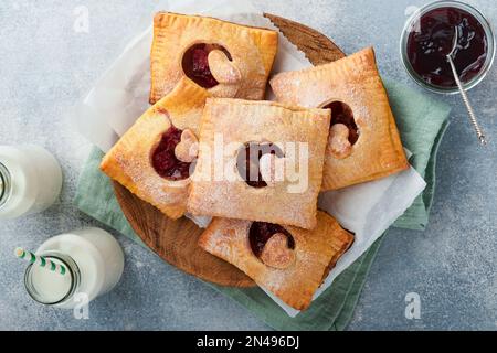 Valentinstag herzförmige Handkuchen. Mini-Blätterteig oder Handkuchen gefüllt mit Apfel und streuen Sie Zuckerpulver auf den Teller. Eine Idee für hausgemachte Romantiker Stockfoto