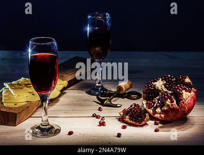 Roter Granatapfelwein in romantischer Abendatmosphäre Stockfoto