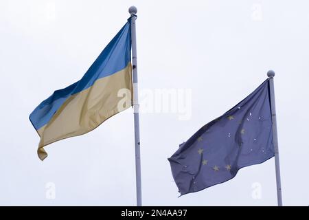 Beschädigte Flaggen der Ukraine und der Europäischen Union, die im Februar 2023 in Irpin, Ukraine, gehäutet haben Stockfoto