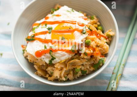 Kimchi-Reis mit Zwiebeln, Spiegelei, sriracha Stockfoto