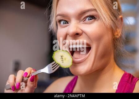 Nahaufnahme des Gesichts einer Frau, die mit offenem Mund lustige Gesichter macht Stockfoto