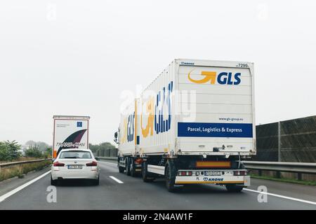 Österreich – 30. Sept. 2014: Rückansicht der weißen Fracht GLS Parcel Logistics Express CARGO Krone LKW fährt neben BMW Serie 5 auf österreichischer Autobahn Stockfoto