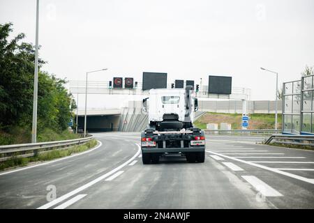 Österreich - 30. Sept. 2014: Rückansicht eines weißen Mercedes-Benz-Lkws, der schnell auf einer leeren österreichischen Autobahn fährt, mit Geschwindigkeitsbegrenzung auf digitaler Anzeige 80km h. Stockfoto