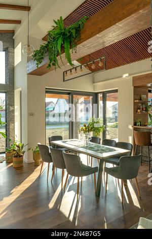 Modernes Haus mit Natur Vibe hölzerne felsige Details und Pflanzen und große Fenster Stockfoto