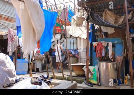 Dezember 21 2022 - Mumbai, Maharashtra in Indien: Menschen waschen Kleidung im Dhobi Ghat Wäschebezirk, einem bekannten Freiluft-Waschsalon Stockfoto