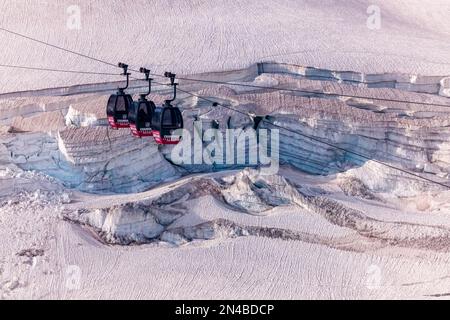 Drei Kabinen der Panoramaseilbahn Mont Blanc, die den Géant-Gletscher mit Spalten und Abbrechungen überqueren. Stockfoto