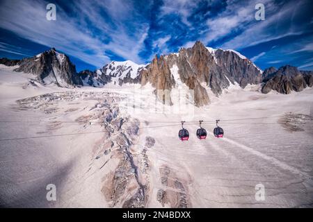 Drei Kabinen der Panorama-Seilbahn Mont Blanc, die den Géant-Gletscher, La Tour Ronde, Mont Blanc und Mont Blanc du Tacul in der Ferne überqueren. Stockfoto