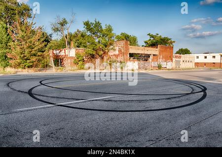 Schwarze Reifenspuren bilden runde Donuts auf der Hamilton Avenue. Stockfoto