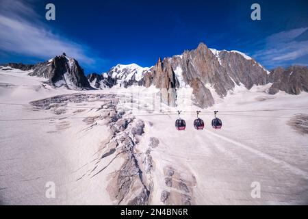 Drei Kabinen der Panorama-Seilbahn Mont Blanc, die den Géant-Gletscher, La Tour Ronde, Mont Blanc und Mont Blanc du Tacul in der Ferne überqueren. Stockfoto