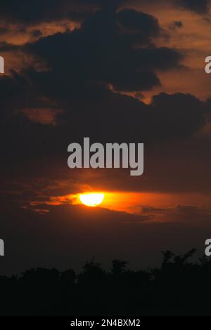 Die goldene Sonne versinkt am Himmel des Dorfes Bangladesch. Das ist die Szene im Sommer. Stockfoto