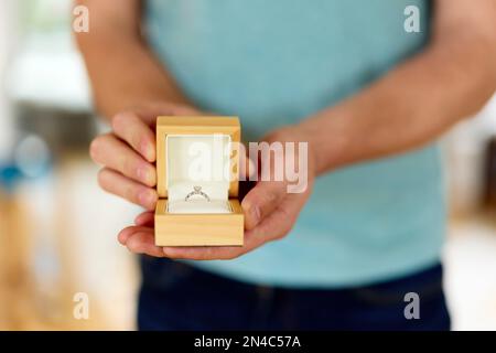 Ein Mann, der einen offenen Verlobungsring hält und präsentiert Stockfoto