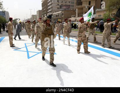 Supporters of Iraqi Hezbollah brigades marching in military uniforms ...