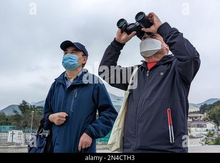 Lim Kian-sang (R), 69, und sein Freund stiegen aus einem Bus vor der neuen Grenzübergangsstelle Heung Yuen Wai und sie zeigten ein Fernglas nach Norden auf ein Apartmenthaus auf der anderen Seite der Grenze zu Shenzhen. 05FEB23 SCMP/Kahon Chan Stockfoto