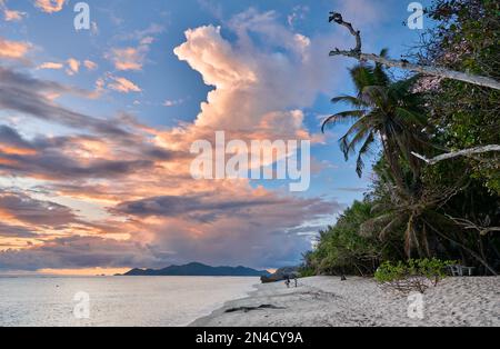 Sonnenuntergang und Wolken über Praslin vom Strand von Anse Source D'Argent, L'Union Estate, La Digue, Seychellen aus gesehen Stockfoto