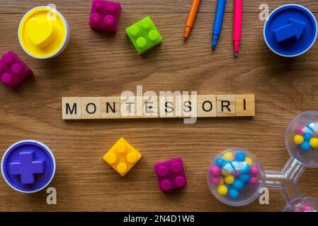 Montessori über ein hölzernes Alphabet-Konzept mit Spielzeug auf Holzhintergrund. Stockfoto