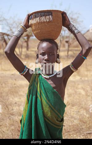 Mursi-Junge mit Korb auf dem Kopf in der ländlichen Gegend von Süd-Äthiopien © Antonio Ciufo Stockfoto