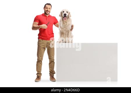 Ein Mann, der eine Schere hält und einen Retriever-Hund umarmt, isoliert auf weißem Hintergrund Stockfoto