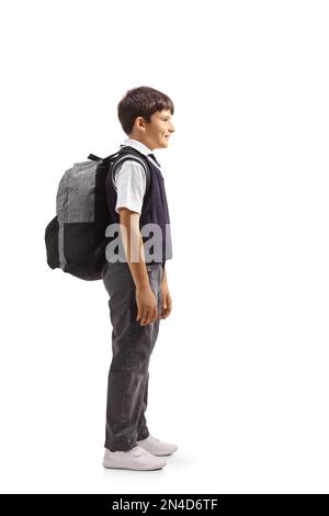 Durchgehende Profilaufnahme eines Jungen in einer Schuluniform mit Rucksack und isoliert auf weißem Hintergrund Stockfoto