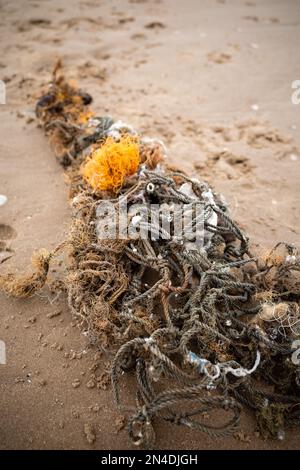 Am Strand angespültes Fischernetz verbirgt sich in die Unterwasserwelt Stockfoto