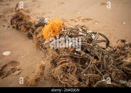 Am Strand angespültes Fischernetz verbirgt sich in die Unterwasserwelt Stockfoto