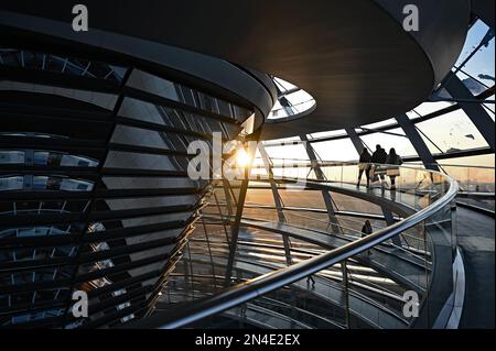 Berlin, Deutschland. 08. Februar 2023. Die Menschen gehen bei Sonnenuntergang durch die Kuppel des Reichstags. Kredit: Philipp Znidar/dpa/Alamy Live News Stockfoto