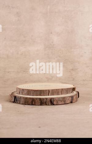 Runde Sägezylinderform aus Holz für Produktpräsentation auf beigem Hintergrund. Runde geometrische Form des Zylinders. Umweltfreundlicher Style und Minimalismus. w Stockfoto