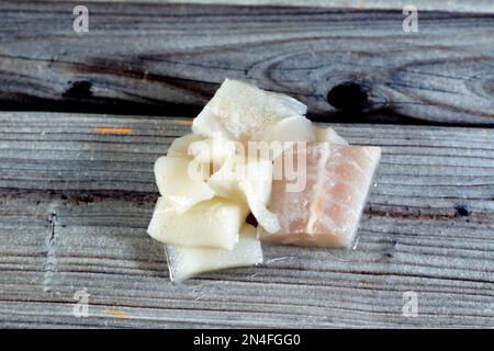 Frisch geschnittene Stücke gefrorener Calamari und Fischfilet, fertig zum Kochen in einer Meeresfrüchtesuppe oder in Meeressalat, traditionelle Mahlzeit, frische Stücke C. Stockfoto