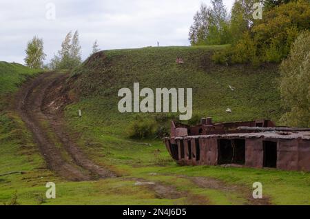 Verlassener Teil des rostigen Eisenschiffs - der Rest der Industrie der Sowjetunion in den wilden Wäldern der Tundra von Yakutia liegt an der Straße. Stockfoto