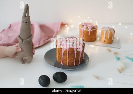Osterkuchen, bunte Eier und Kaninchenspielzeug. Frohe Osterferien Konzept. Festliche Frühlingszeit Stockfoto